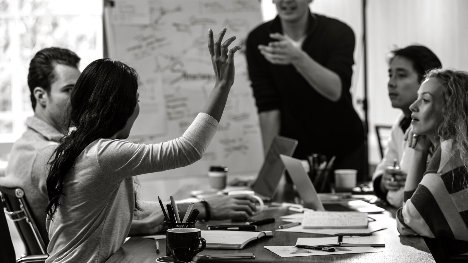 One hand raised in a meeting