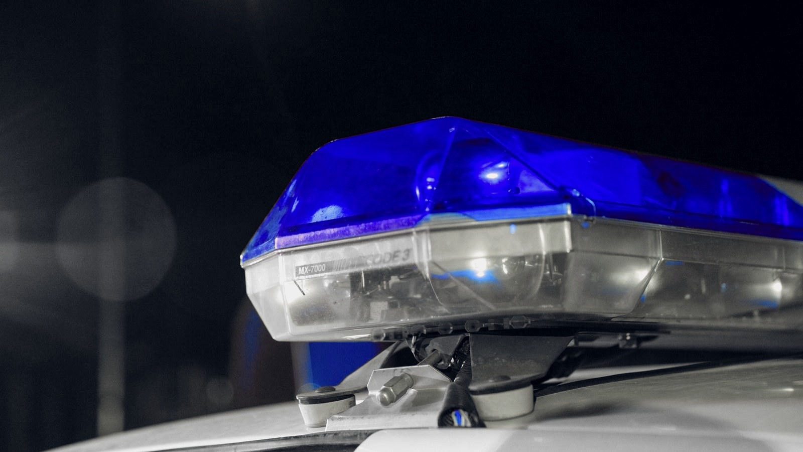 Blue light bar on a police cruiser at night.
